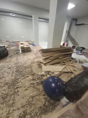 Χώρος μετά από ανακαίνιση πριν τον καθαρισμό: ξύλα και σκουπίδια στο πάτωμα